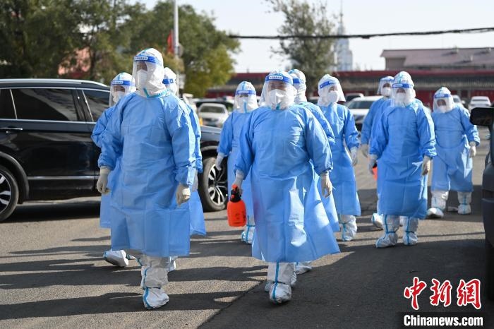 圖為醫(yī)務(wù)人員在封閉小區(qū)做防控工作?！⑽娜A 攝