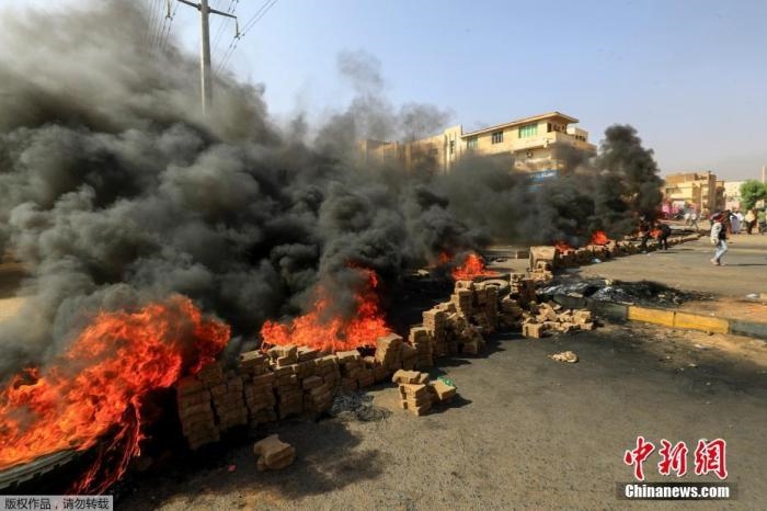 當?shù)貢r間10月25日，蘇丹局勢發(fā)生突變，過渡政府總理被“綁架”，政府部長被軍方抓捕，國家進入緊急狀態(tài)，大量民眾走上街頭對軍方行動進行抗議，已有7人在抗議活動中死亡，140人受傷。圖為抗議活動中燃燒的輪胎。