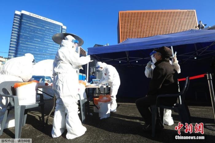 資料圖：韓國首爾，醫(yī)務(wù)人員對市民進(jìn)行新冠病毒檢測。