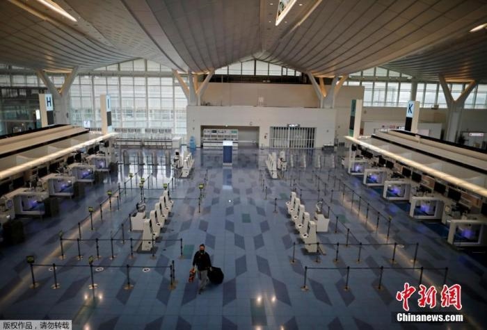 資料圖：日本東京，東京國際機場，一名乘客在國際航班航站樓的登機區(qū)。