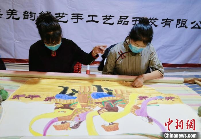 圖為皮繡藝人在市集上“秀”指尖技藝?！●R銘言 攝