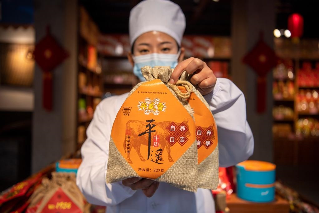 1月27日，在平遙古城南大街的一家平遙牛肉店內(nèi)，工作人員展示一款牛肉產(chǎn)品。新華社記者 楊晨光 攝