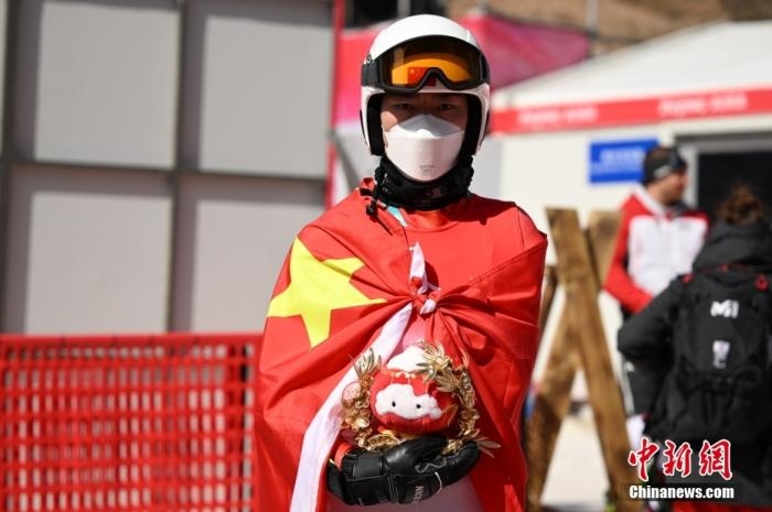 3月6日，中國選手梁景怡在賽后手捧吉祥物。當日，北京2022年冬殘奧會殘奧高山滑雪男子超級大回轉-站姿決賽在國家高山滑雪中心舉行，中國選手梁景怡奪得冠軍。 <a target='_blank' href='/'>中新社</a>記者 劉冉陽 攝 　