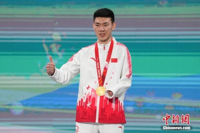 3月6日，梁景怡在延慶頒獎廣場領獎臺上豎起大拇指。當日，在國家高山滑雪中心舉行的北京2022年冬殘奧會殘奧高山滑雪男子超級大回轉—站姿決賽中，中國選手梁景怡奪得冠軍。 <a target='_blank' href='/'>中新社</a>記者 楊華峰 攝