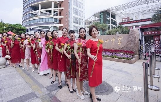 6月7日一早，廈門雙十中學(xué)考生家長(zhǎng)們身穿旗袍，手拿向日葵在考場(chǎng)外為孩子加油打氣，寓意“旗開(kāi)得勝，一舉奪魁”。人民網(wǎng)記者 陳博攝