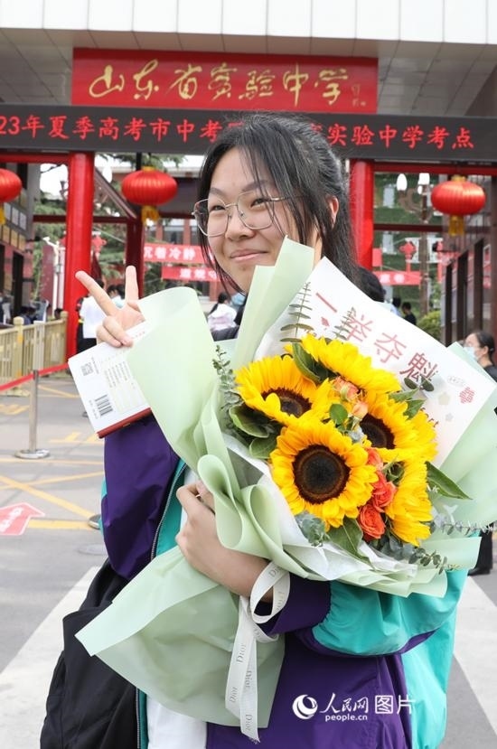 6月7日高考首日，山東67萬(wàn)考生走進(jìn)考場(chǎng)，拼搏逐夢(mèng)。在山東省實(shí)驗(yàn)中學(xué)考點(diǎn)，考生進(jìn)考場(chǎng)前手捧向日葵花拍照留念，寓意“一舉奪魁”。人民網(wǎng)記者 劉祺攝