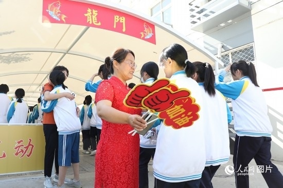 6月7日一早，雄安新區(qū)安新中學(xué)老師在給同學(xué)們加油鼓勁兒。人民網(wǎng) 李兆民攝