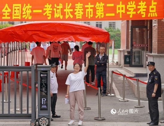 6月7日，在長(zhǎng)春市第二中學(xué)考點(diǎn)，一名考生信心滿滿進(jìn)入考場(chǎng)，并與家長(zhǎng)揮手致意。人民網(wǎng)記者 李洋攝