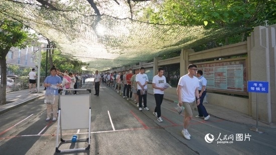 6月7日，烏魯木齊市第七十中學(xué)門口，考生們有序進(jìn)入考場(chǎng)。人民網(wǎng) 李欣洋攝