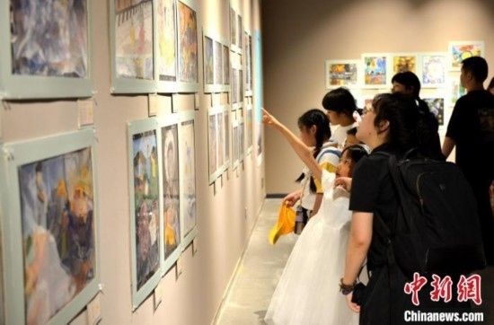 圖為家長帶著孩子參觀展覽。呂明 攝