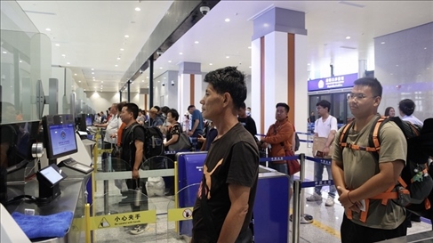 6月13日，乘坐中老鐵路國際旅客列車的旅客在磨憨邊檢大廳排隊(duì)候檢。李揚(yáng) 攝