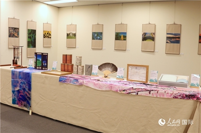 現(xiàn)場(chǎng)展出的馮學(xué)敏攝影作品與湖州市特色工藝品。（人民網(wǎng) 許可攝）