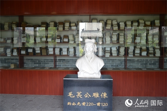 河間詩經(jīng)齋毛萇雕像。雕像后書櫥中陳列的是歷代各版本《詩經(jīng)》及譯本。 人民網(wǎng) 趙昭攝