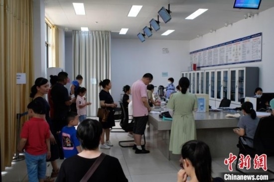 圖為在戶籍辦證廳內排隊等待的家長和孩子。劉俊聰 攝