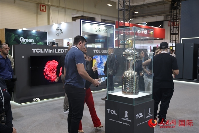 參觀者在TCL展臺前觀看南美解放者杯獎杯，據(jù)介紹，TCL是南美解放者杯（2023—2026賽季）全球官方合作伙伴。（人民網(wǎng)記者 時元皓攝）