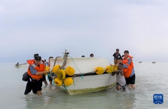 7月21日，中國海軍“和平方舟”號醫(yī)院船醫(yī)護人員涉水登島，前往基里巴斯一診療點。新華社記者 黎云 攝