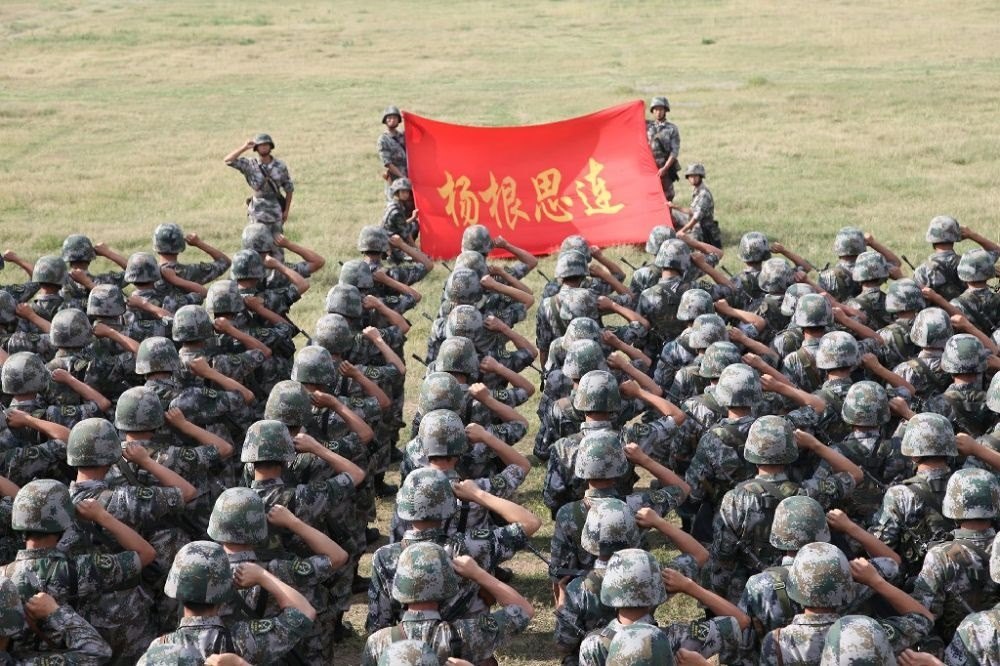 ↑“楊根思連”官兵執(zhí)行任務(wù)前向連旗宣誓（資料照片）。新華社發(fā)