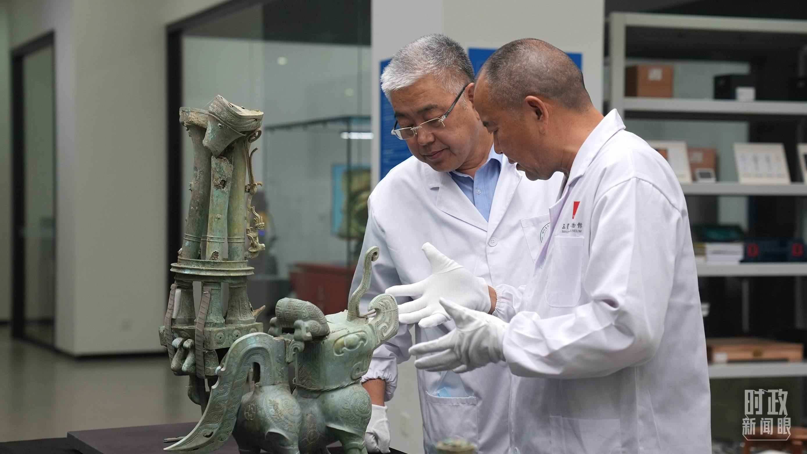 △三星堆文保專家正在就修復(fù)方案進(jìn)行討論。（總臺央視記者劉琦拍攝）