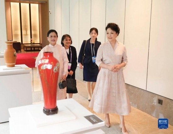 7月27日下午，國(guó)家主席習(xí)近平夫人彭麗媛在四川成都會(huì)見陪同印度尼西亞總統(tǒng)佐科來(lái)華出席第31屆世界大學(xué)生夏季運(yùn)動(dòng)會(huì)開幕式并訪華的總統(tǒng)夫人伊莉亞娜。這是彭麗媛和伊莉亞娜欣賞成都特色非遺工藝品。新華社記者 丁林 攝