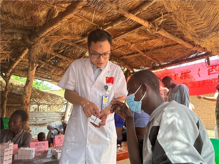圖為南昌大學(xué)第一附屬醫(yī)院病理科主治醫(yī)師張振東為村民解說藥品使用方法。中國駐乍得醫(yī)療隊供圖