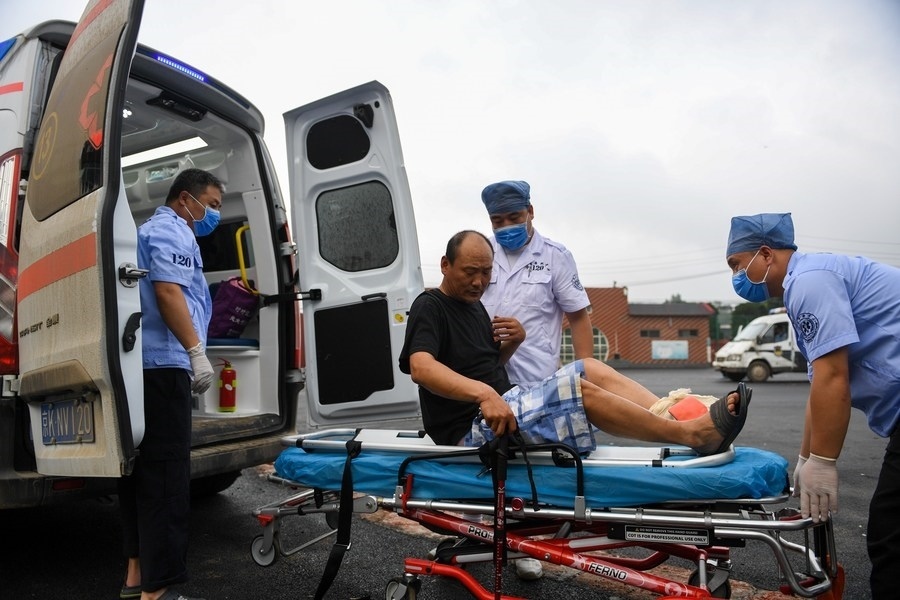 8月1日，在北京市門頭溝區(qū)妙峰山鎮(zhèn)妙峰山民族學(xué)校臨時安置點，北京急救中心工作人員在轉(zhuǎn)運一名受傷村民。新華社記者 鞠煥宗 攝