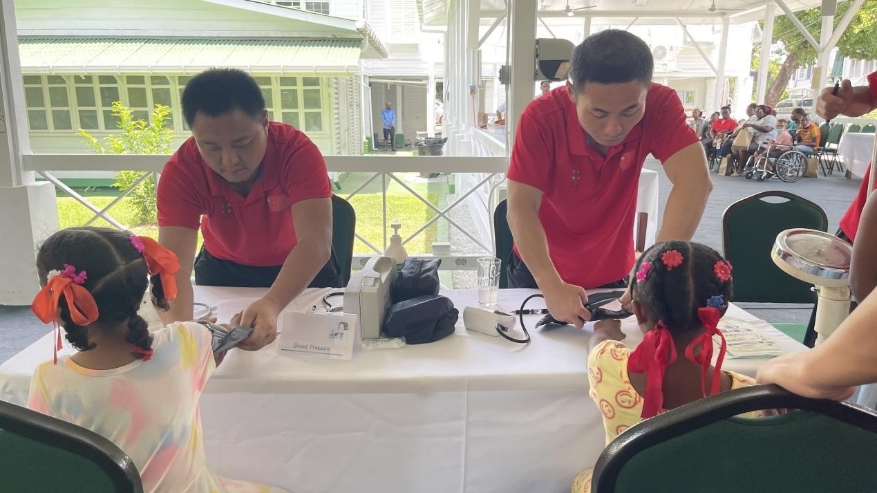 醫(yī)療隊(duì)員為福利院兒童進(jìn)行檢查。第18期援圭亞那醫(yī)療隊(duì)供圖