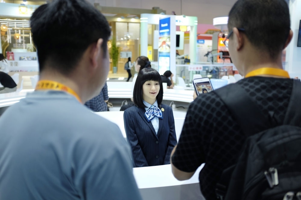 9月1日，媒體記者在國家會議中心與服務(wù)機器人互動。新華社記者 劉夢琪 攝