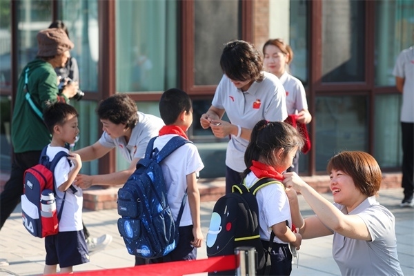 8月30日，雄安史家胡同小學(xué)學(xué)生體驗學(xué)校生活。老師為學(xué)生佩戴?；铡? /></p> <p style=