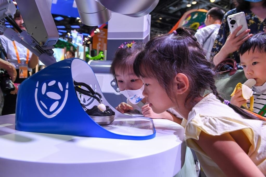 9月3日，幾名小朋友在國(guó)家會(huì)議中心觀看單孔腔鏡手術(shù)機(jī)器人展示。新華社記者 鞠煥宗 攝