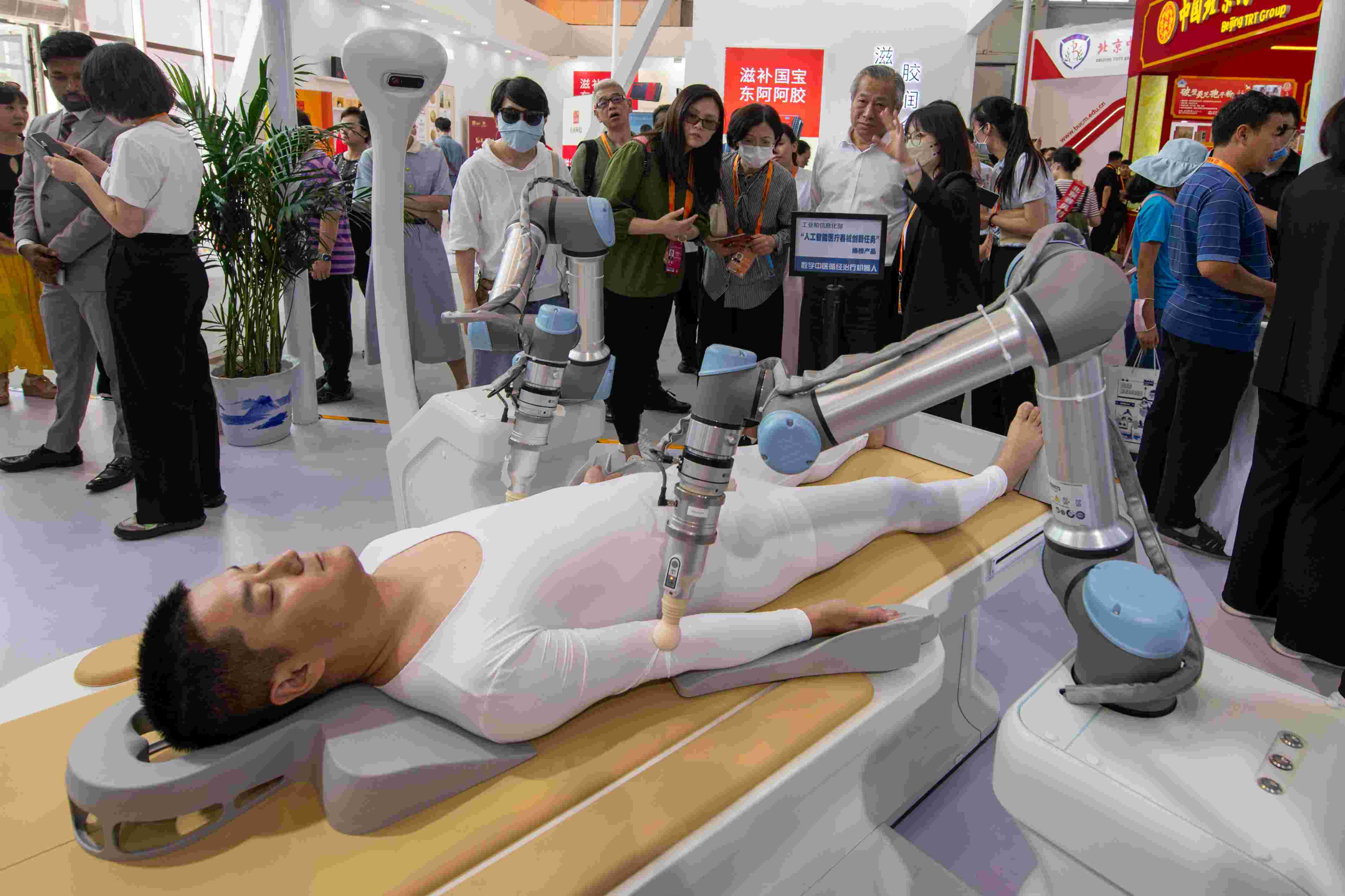 在位于首鋼園的健康衛(wèi)生服務(wù)展區(qū)，觀眾正在參觀數(shù)字中醫(yī)循經(jīng)治療機器人。人民網(wǎng)記者 翁奇羽攝