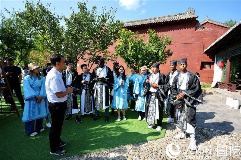 圖為選手們聽導(dǎo)游講解。人民網(wǎng) 盧鵬宇攝