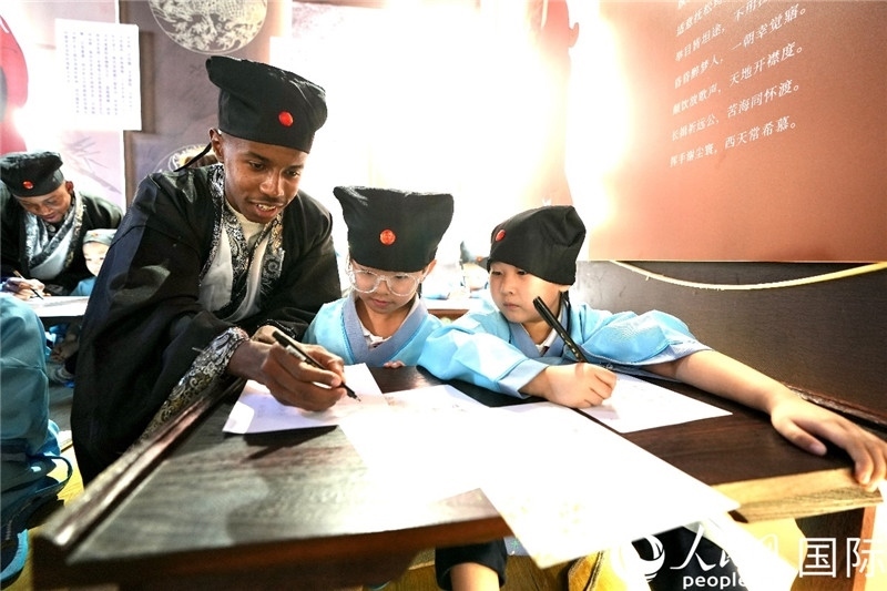 圖為選手與同學(xué)們一起寫書法。人民網(wǎng) 盧鵬宇攝