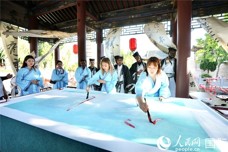 選手們提筆書寫“家園”二字。人民網(wǎng) 盧鵬宇攝