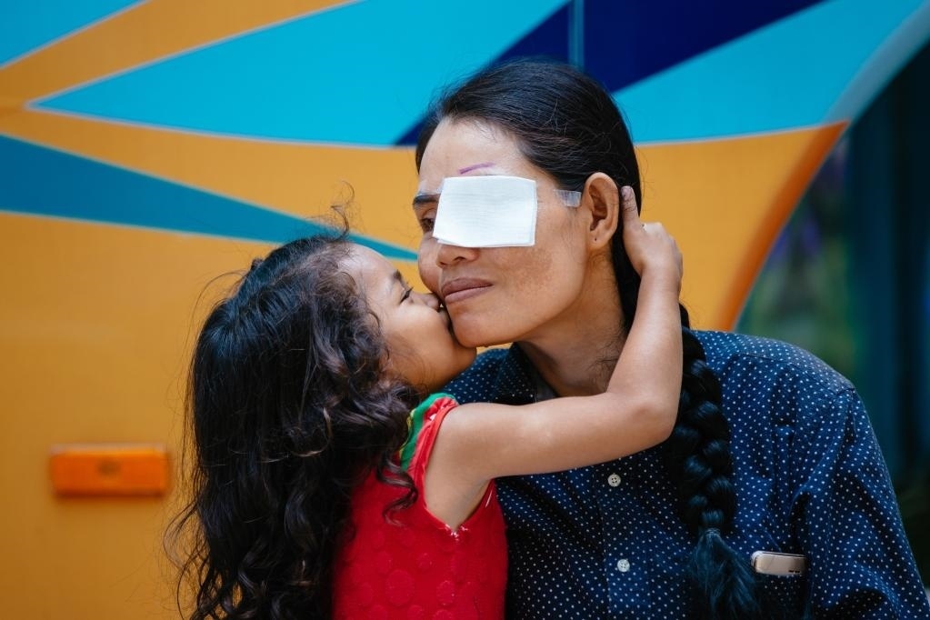 2019年3月15日，在柬埔寨磅湛省醫(yī)院，即將接受白內(nèi)障手術(shù)的患者孫美樂接受女兒的親吻祝福。在接受了中國醫(yī)療隊的白內(nèi)障義診手術(shù)后，她的視力逐步恢復(fù)，生活有了新的光明和希望。