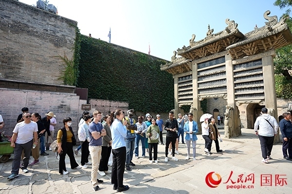 選手們認(rèn)真聆聽導(dǎo)游講解。人民網(wǎng) 盧鵬宇攝