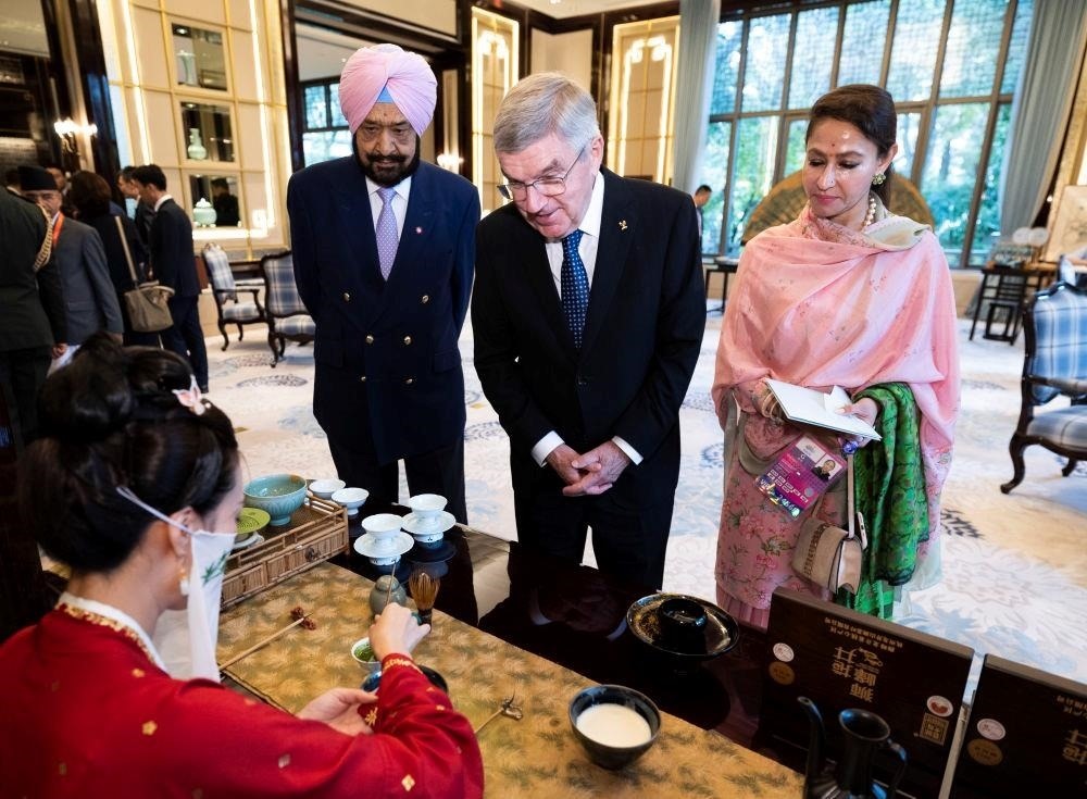 △歡迎宴會前，亞奧理事會代理主席辛格和夫人維尼塔、國際奧委會主席巴赫欣賞非遺展示。