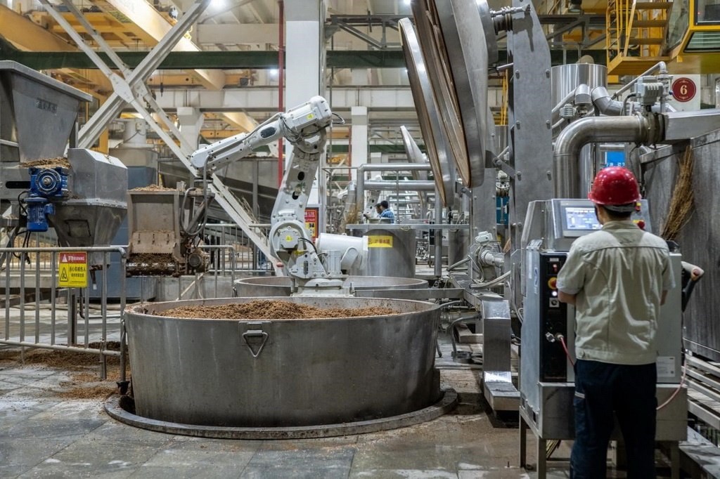 907車間里，機(jī)械臂正在撒料裝甑。嚴(yán)磊攝