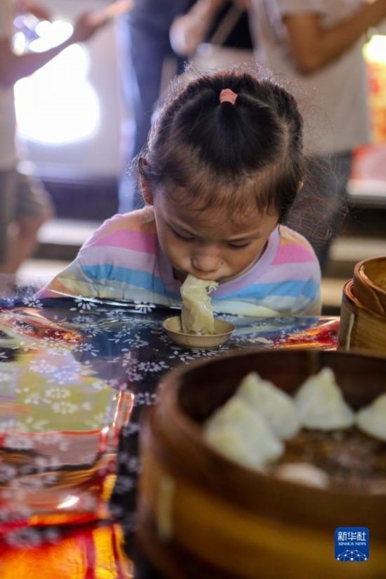 9月27日，小朋友在南翔小籠長(zhǎng)街宴上品嘗南翔小籠。