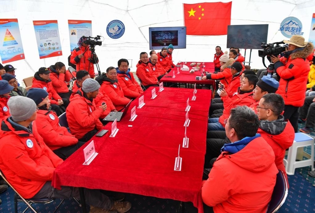 海拔4950米的卓奧友峰科考大本營，科考隊員趙華標（手拿麥克風(fēng)看電腦者）在宣讀剛剛接收到的頂峰氣象觀測數(shù)據(jù)，這標志著峰頂自動氣象站架設(shè)成功，成功傳回觀測數(shù)據(jù)（10月1日攝）。新華社記者晉美多吉 攝