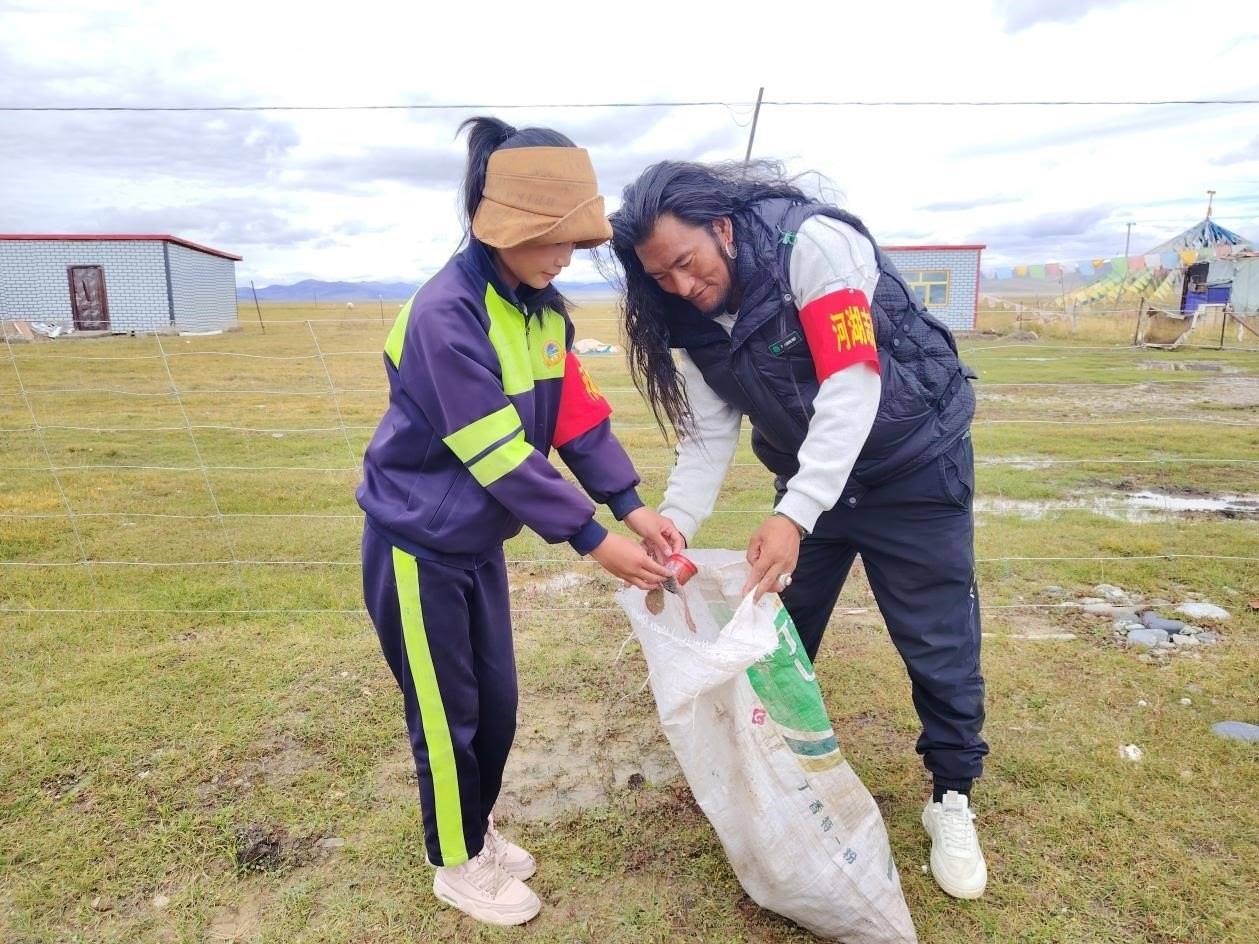 玉樹州稱多縣珍秦鎮(zhèn)河湖志愿者才培和他女兒更求拉毛在清掃垃圾。受訪者供圖