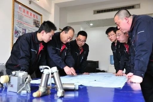 △李志強(qiáng)（左二）與班組成員在研究工作。