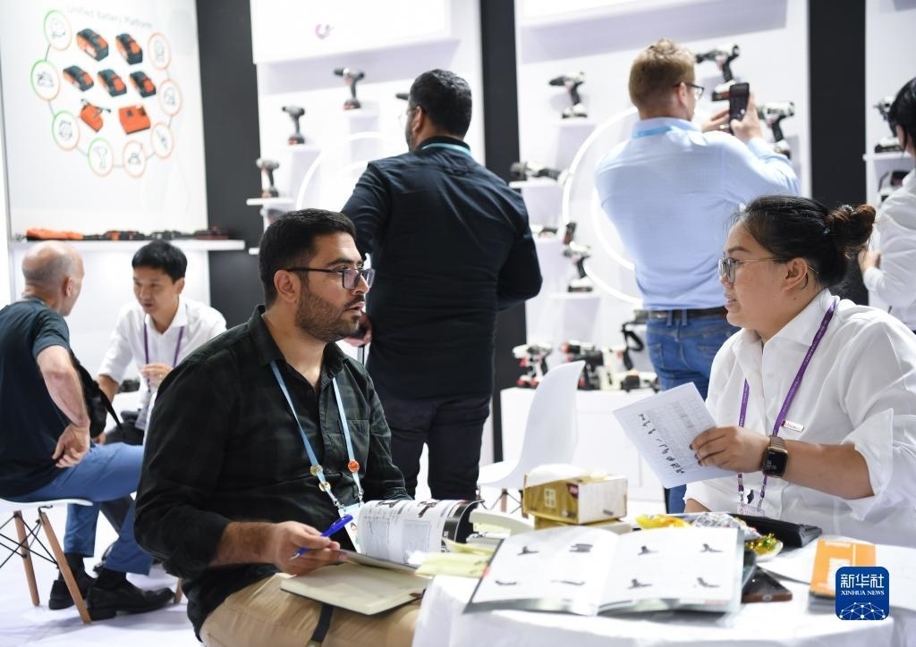 10月15日，在一家電動工具展臺，外國采購商在洽談業(yè)務(wù)。新華社記者 鄧華 攝