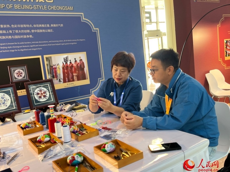 記者在新聞中心非遺傳承人展區(qū)進行體驗。人民網(wǎng)記者 杜燕飛攝