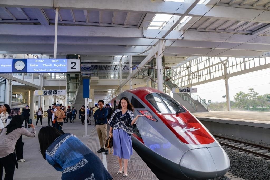 10月17日，在印度尼西亞萬(wàn)隆德卡魯爾站，乘客在站臺(tái)上和雅萬(wàn)高鐵高速動(dòng)車(chē)組列車(chē)合影。