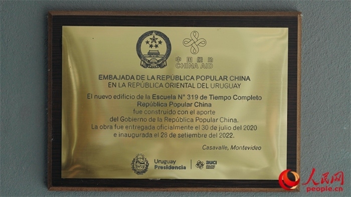 小學(xué)墻上懸掛的中國援助標(biāo)識(shí)。人民網(wǎng)記者 張若涵攝