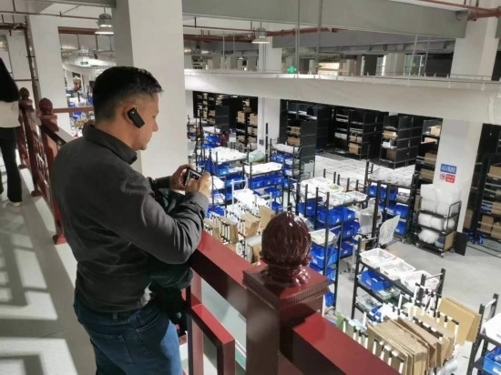 2023“一帶一路”媒體合作論壇聯(lián)合采訪團(tuán)團(tuán)員在仁和醫(yī)藥物流園拍攝記錄轉(zhuǎn)運(yùn)流程。（本報(bào)記者 黃超攝）