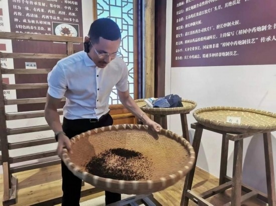 2023“一帶一路”媒體合作論壇聯(lián)合采訪團(tuán)團(tuán)員在非遺文化展示館體驗(yàn)中藥炮制技藝。（本報(bào)記者 黃超攝）