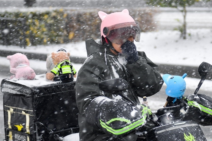 11月6日，在長(zhǎng)春市街頭，一名外賣員在雪中騎行。新華社記者 許暢 攝