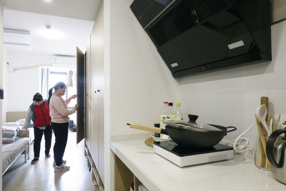 住戶在閔行區(qū)新時代城市建設者管理者之家收拾房間。