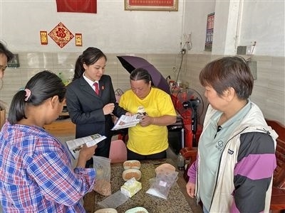  圖⑤：龍圩區(qū)法院法官到群眾家中開展法治宣傳。資料圖片